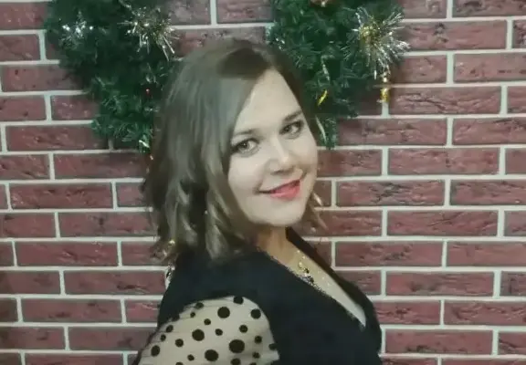 Наталия Афанасьева позирует у кирпичной стены