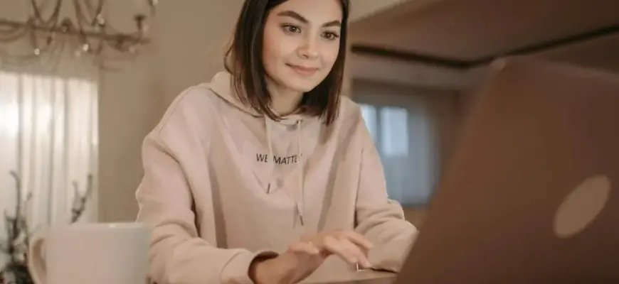 Что написать после молчания: девушка за ноутбуком обдумывает сообщение и возвращается к переписке