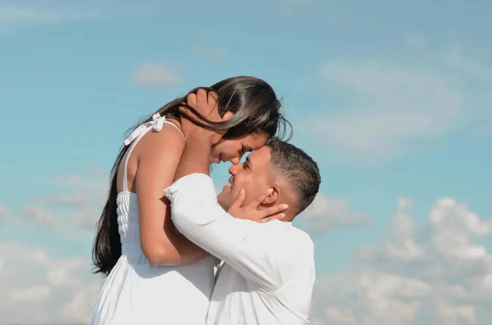 Как быть, если у влюбленных очень различный уровень доходов — пара в белой одежде обнимается на фоне неба