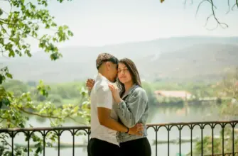 Как не волноваться перед первым свиданием — пара обнимается у перил на смотровой площадке с видом на природу