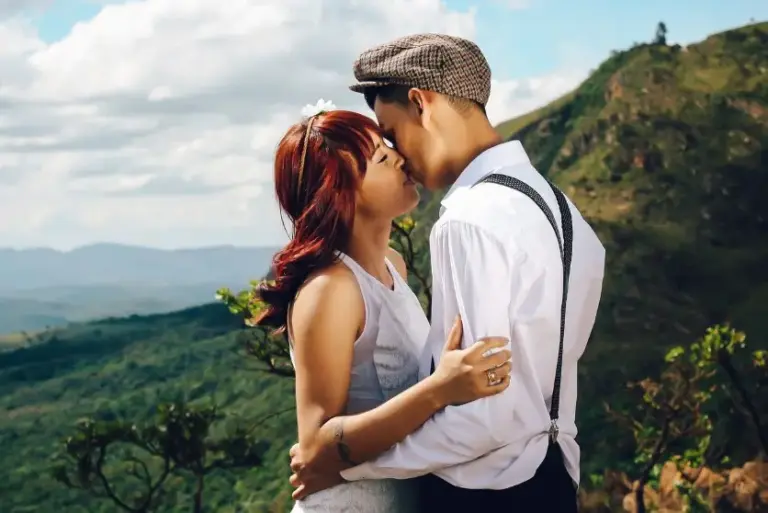 Какие темы нельзя обсуждать на первом свидании: пара обнимается на фоне гор и природы
