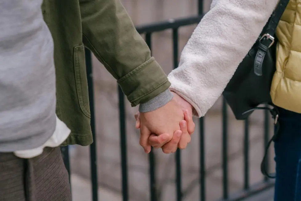 Ошибки в переписке, которые “убивают” интерес — пара держится за руки на прогулке, крупный план