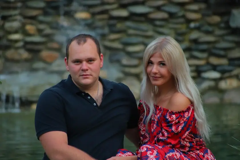 Почему писать первой — нормально: пара у воды на фоне каменной стены, спокойная романтическая атмосфера