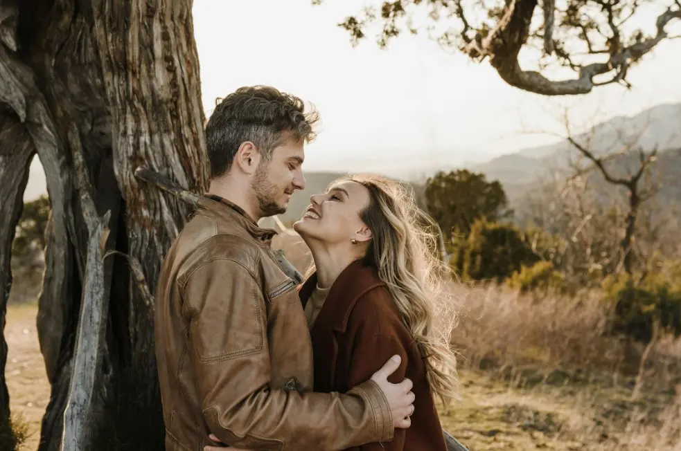 Почему повторяются сценарии отношений — мужчина и женщина обнимаются у дерева на природе и смотрят друг на друга
