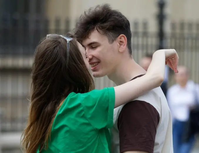 Пара обнимается и улыбается, размышляя, расставаться или нет с партнером