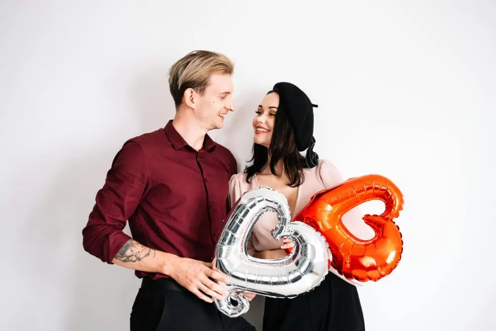 Совместный бюджет: как вести бюджет в паре — мужчина и женщина улыбаются и держат воздушные шары в форме сердца, ощущение команды и согласия