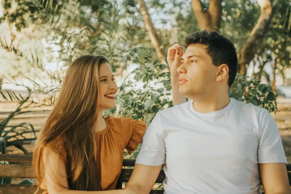 Совместный бюджет: как вести бюджет в паре — девушка улыбается и разговаривает с парнем на скамейке, спокойное обсуждение денег и договорённости без конфликтов