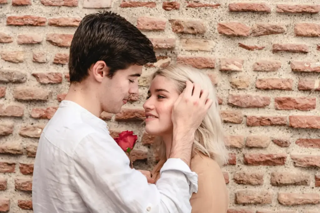 Вопросы для начала переписки — парень и девушка с розой у кирпичной стены, романтичный момент знакомства