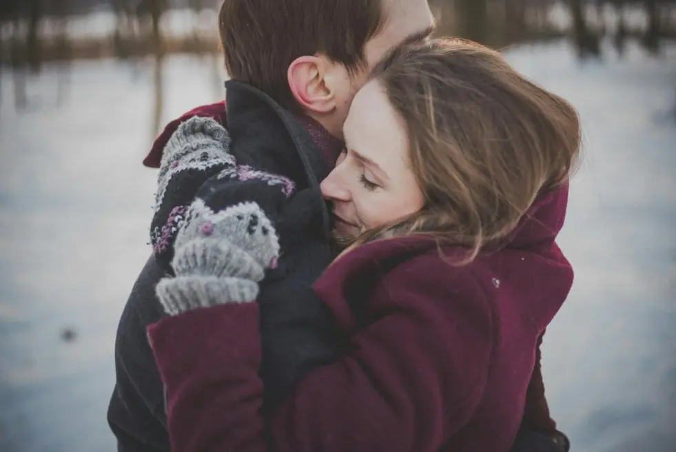 Я тащу все на себе, не могу расслабиться — пара обнимается зимой на улице, тёплая поддержка и чувство безопасности, момент доверия в отношениях